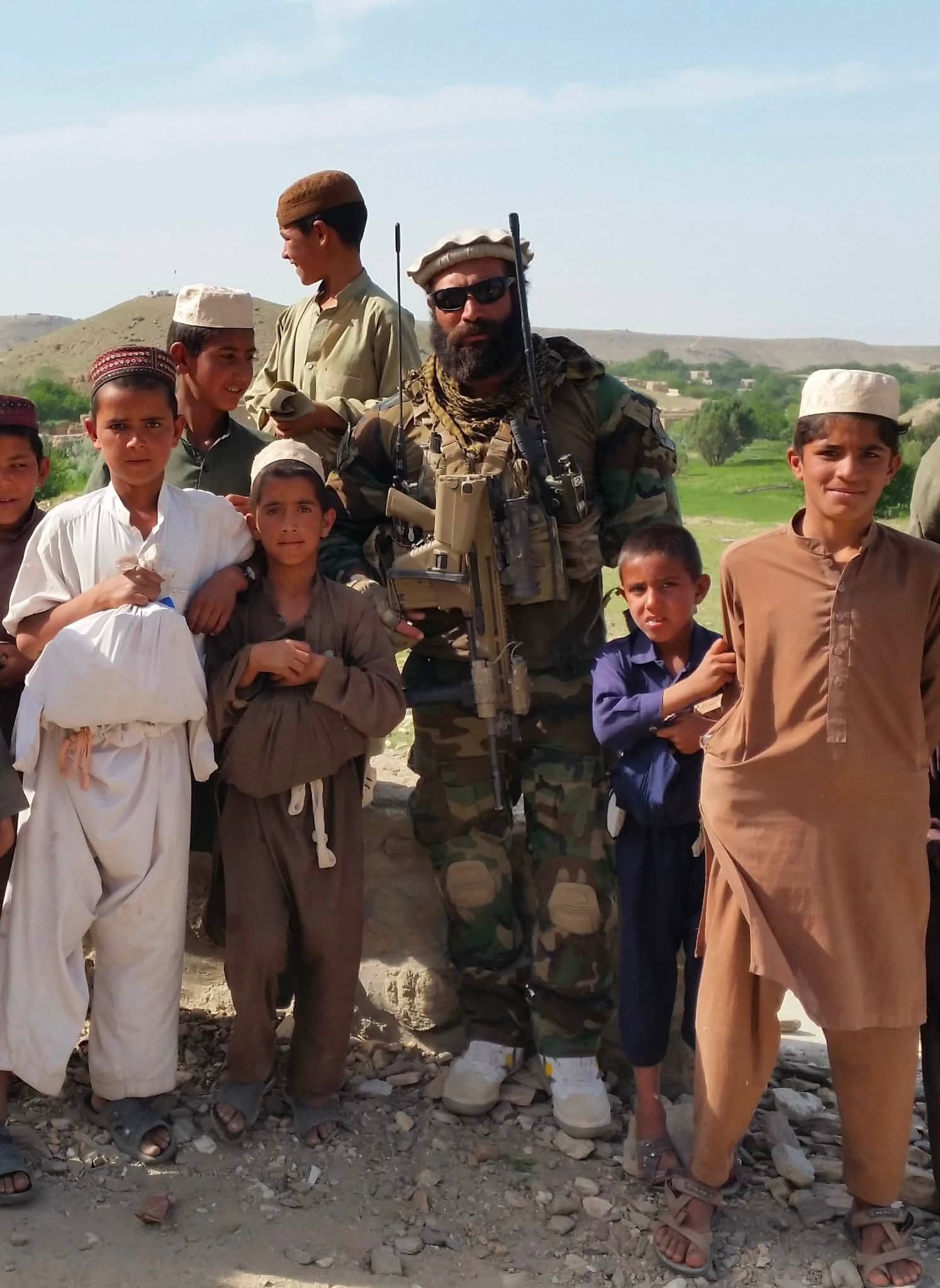 Sam on deployment with local children in Afghanistan