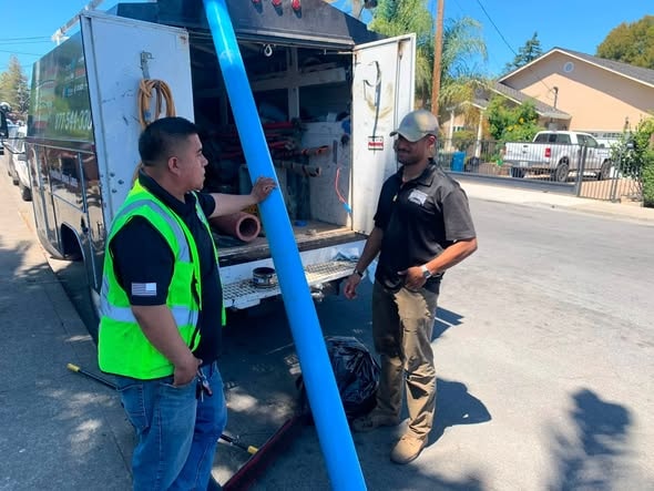Plumbing workers with service vehicle