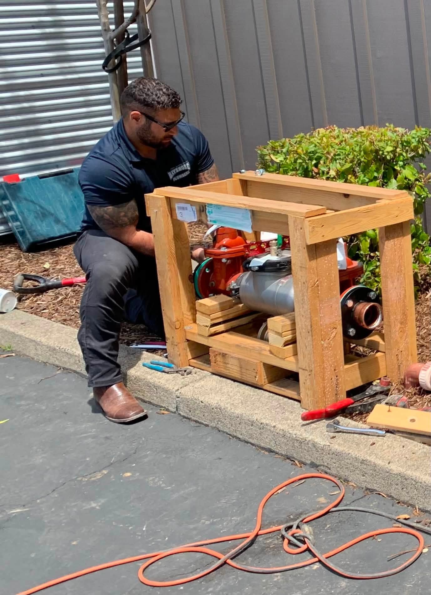 Plumber working on backflow preventer assembly